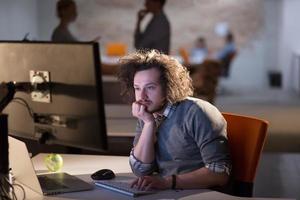 man working on computer in dark office photo