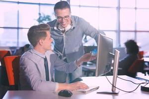 dos personas de negocios que trabajan con una computadora en la oficina foto