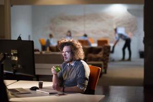 man working on computer in dark office photo