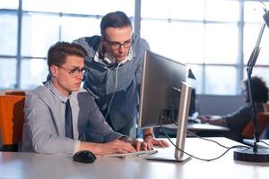 dos personas de negocios que trabajan con una computadora en la oficina foto