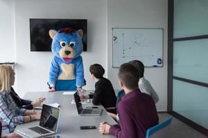 boss dresed as bear having fun with business people in trendy office photo