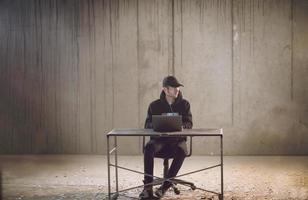 talented hacker using laptop computer while working in dark office photo