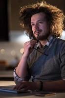 man working on computer in dark office photo