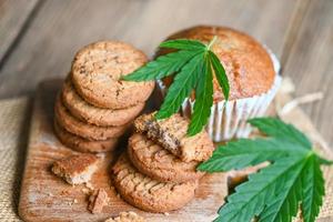 delicious sweet dessert cookie with hemp leaf plant THC CBD herbs food snack and medical, Cannabis food cookies with cake chocolate cannabis leaf marijuana herb - top view photo