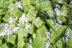 Colorful sweet green pudding cake thai dessert with coconut shredded background photo