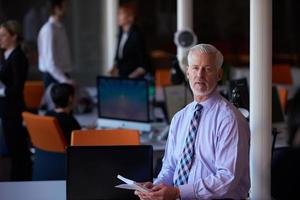 hombre de negocios senior con su equipo en la oficina foto