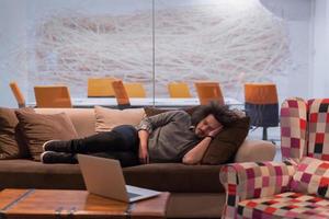 man sleeping on a sofa  in a creative office photo