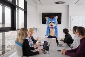 boss dresed as bear having fun with business people in trendy office photo