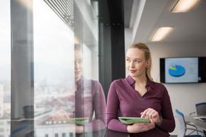 empresaria rubia que trabaja en la tableta en la oficina foto