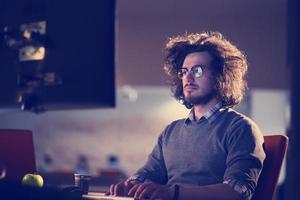 man working on computer in dark office photo