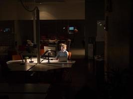 hombre trabajando en una computadora en una oficina oscura foto