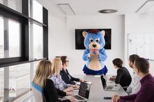 boss dresed as bear having fun with business people in trendy office photo