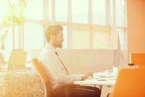 relaxed young businessman first at workplace at early morning photo