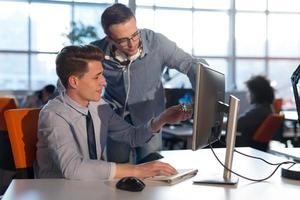 dos personas de negocios que trabajan con una computadora en la oficina foto