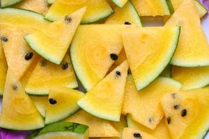 Yellow watermelon slice on background, Closeup pile of sweet watermelon slices pieces fresh watermelon tropical summer fruit - top view photo