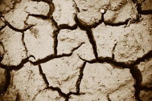 Cracks of the dried soil in arid season Arid soil , Cracked earth texture of ground broken and rough surface mud clay photo