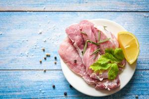 raw pork meat rosemary on white plate with herbs and spices lemon vegetables - fresh pork photo