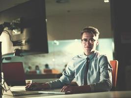 man working on computer in dark office photo