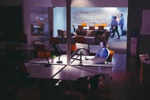 man working on computer in dark office photo