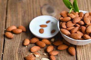 Almond milk and Almonds nuts on on white bowl background, Delicious sweet almonds on the table, roasted almond nut for healthy food and snack photo