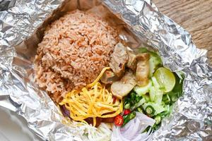 Thai food on box with aluminum foil food wrap takeaway food - rice mixed with shrimp paste fried rice on box,rice seasoned with shrimp paste recipe, rice herbal spices photo