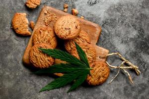 deliciosa galleta de postre dulce con planta de hoja de cáñamo thc cbd hierbas comida bocadillo y medicina, galletas de comida de cannabis con pastel de chocolate hoja de cannabis hierba de marihuana foto