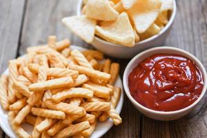 crunchy prawn crackers or shrimp crisp rice and ketchup for traditional snack - prawn crackers stick on white plate and wooden table background photo
