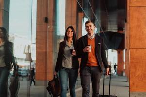 Business man and business woman talking and holding luggage traveling on a business trip photo