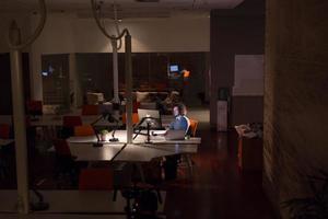 hombre trabajando en una computadora en una oficina oscura foto