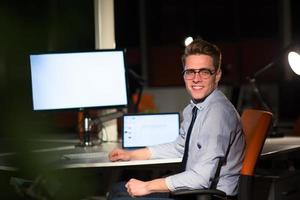 man working on computer in dark office photo