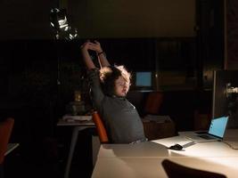 hombre trabajando en una computadora en una oficina oscura foto