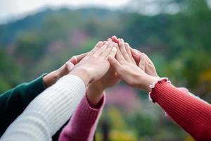 A diverse group of people connects their hands as a supportive sign expressing a sense of teamwork. Unity and togetherness. photo