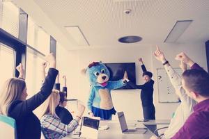 boss dresed as bear having fun with business people in trendy office photo