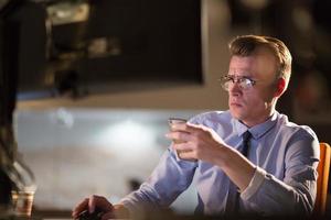 man using mobile phone in dark office photo
