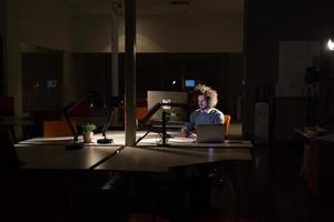 hombre trabajando en una computadora en una oficina oscura foto