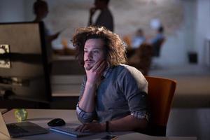 man working on computer in dark office photo