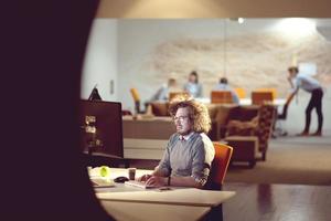 man working on computer in dark office photo