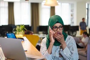 african muslim business woman using mobile phone photo