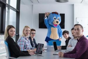 boss dresed as bear having fun with business people in trendy office photo