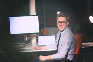 man working on computer in dark office photo