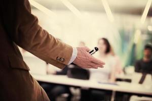 close up of teacher hand while teaching in classroom photo