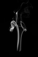 A single white smoke burn from incense, shot in studio with dark black background, for design and religion concept photo