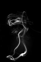 A single white smoke burn from incense, shot in studio with dark black background, for design and religion concept photo