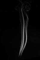 A single white smoke burn from incense, shot in studio with dark black background, for design and religion concept photo