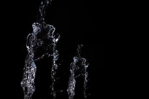 Water splash shot in studio, white water and black background, pure water for drink and food concept copy space for text and design photo