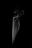 A single white smoke burn from incense, shot in studio with dark black background, for design and religion concept photo