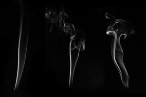 three white smoke burn from incense, shot in studio with dark black background, for design and religion concept photo