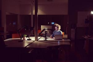 man working on computer in dark office photo