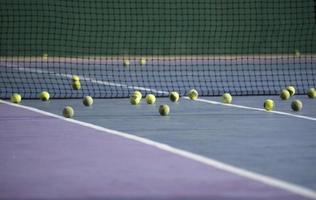 A lot of tennis balls on court photo