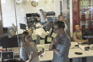 young couple at modern office interior writing notes on stickers photo